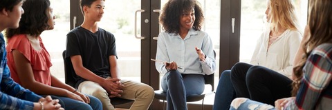 A diverse group of people seated together, engaged in discussion.