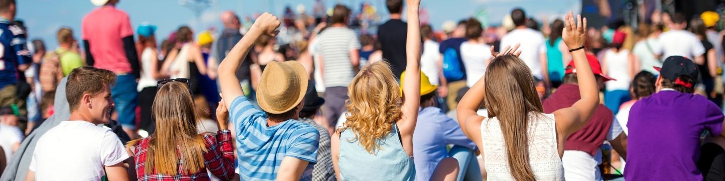 A group of young people at a festival watching a performance