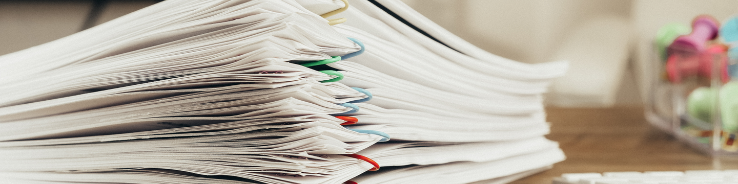 The image shows a stack of paper documents