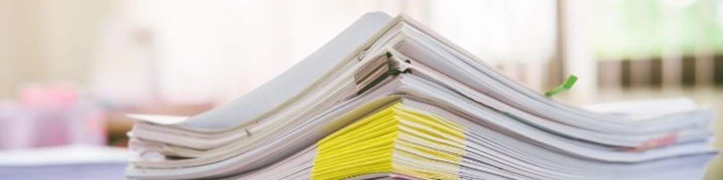 The image shows a stack of paper documents