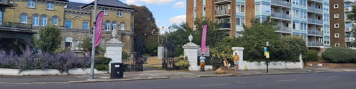 Street-level photograph of the proposed bus stop location, showing the surrounding road environment with Hove Museum prominently visible in the background to provide context for the site.