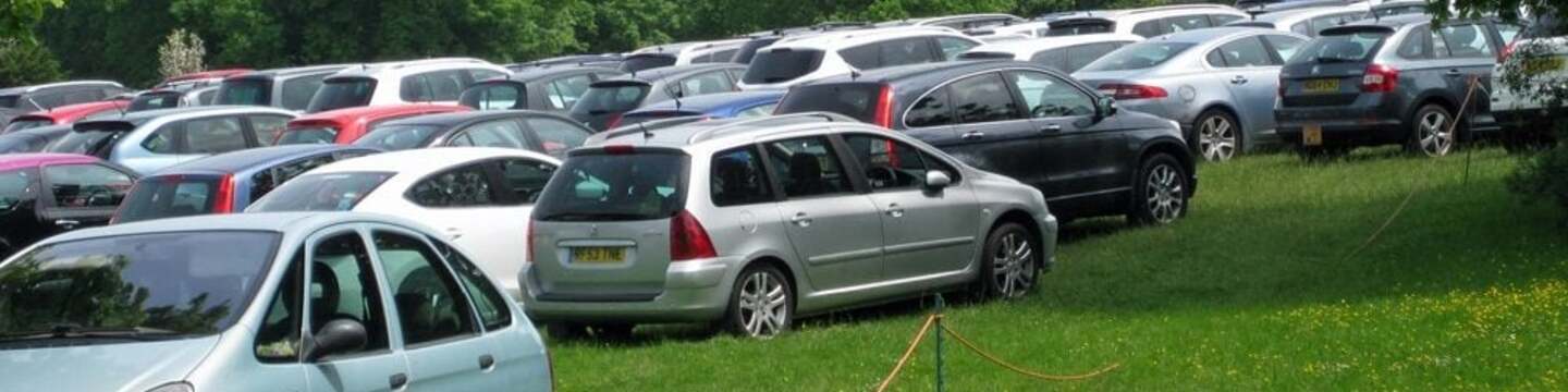 Cars parked in a field.