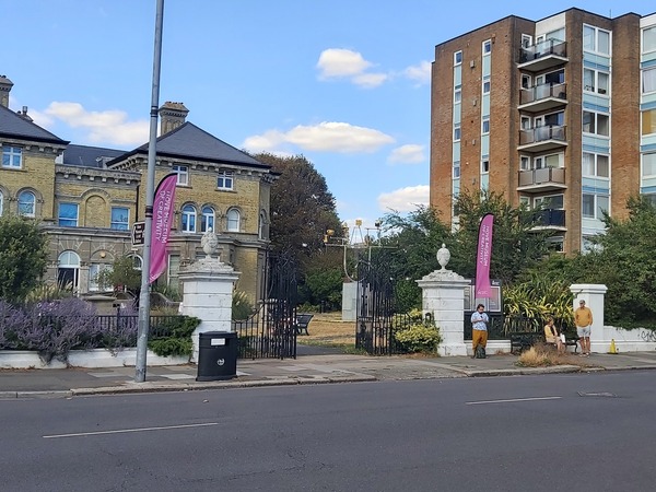 Street-level photograph of the proposed bus stop location, showing the surrounding road environment with Hove Museum prominently visible in the background to provide context for the site.