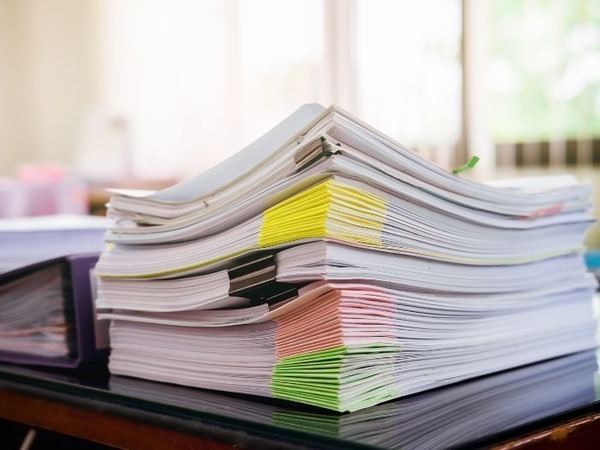 The image shows a stack of paper documents